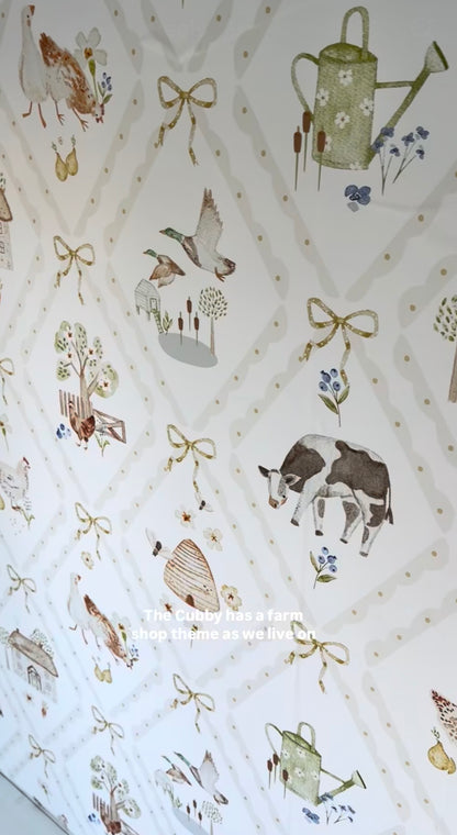Hollybrook Farm peel and stick wallpaper close up showing watercolour cows, hens and ribbon bows on a soft trellis